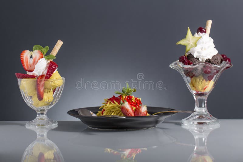 Lot of ice cream cup with fresh fruits on the grey background. Lot of ice cream cup with fresh fruits on the grey background