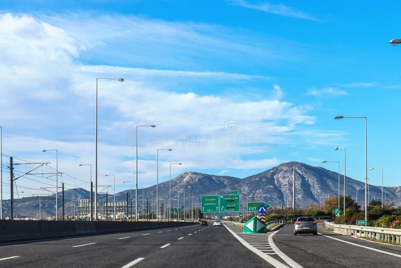 Sortie sur la route en Grèce quittant Athènes vers la péninsule de Péloponnèse avec des montagnes à l'arrière-plan et aux signes image stock Sortie sur la route en Grèce quittant Athènes vers la péninsule de Péloponnèse avec des montagnes à l'arrière-plan et aux signes image stock