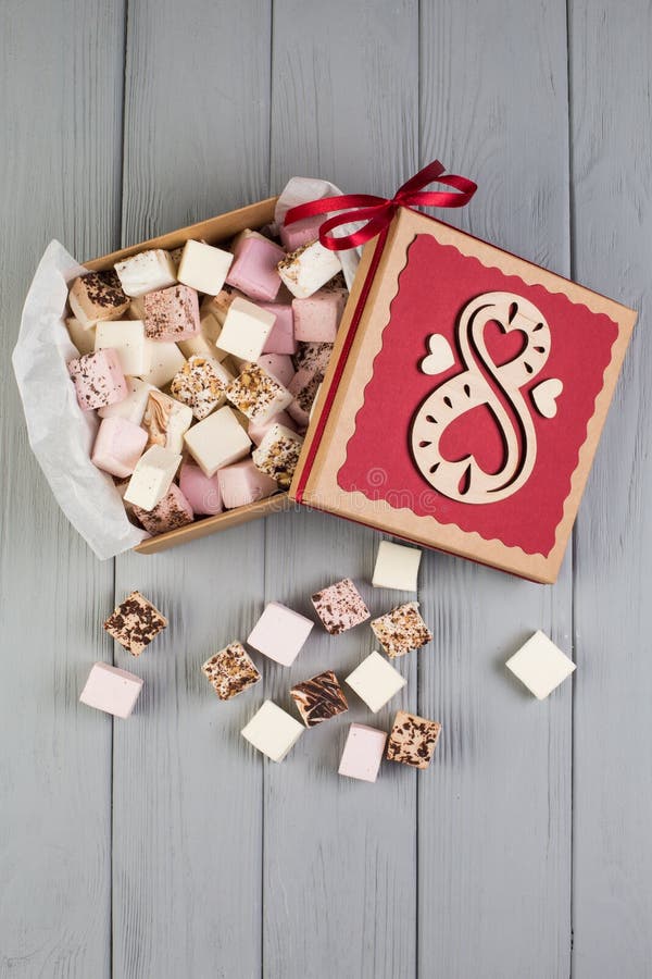 Sortierter Eibisch auf Tabelle mit Geschenkbox für Marsch acht. Sortierter Eibisch auf grauer hölzerner Tabelle mit Geschenkbox für Marsch acht