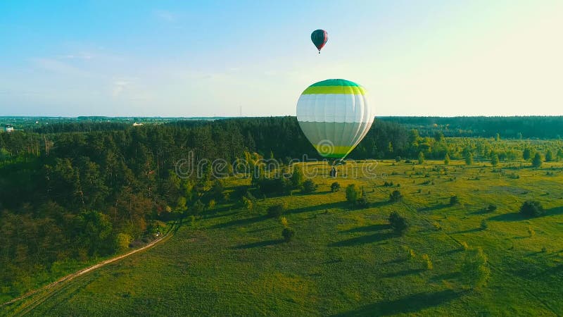 Sorvolare la mongolfiera Mongolfiera nel cielo sopra un campo nella campagna Siluetta dell'uomo Cowering di affari Aria calda