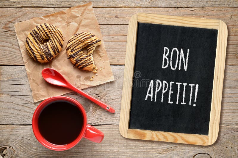 Souhaite l'appetit de fève sur le petits tableau noir, tasse de café et biscuits photographie stock Souhaite l'appetit de fève sur le petits tableau noir, tasse de café et biscuits photographie stock
