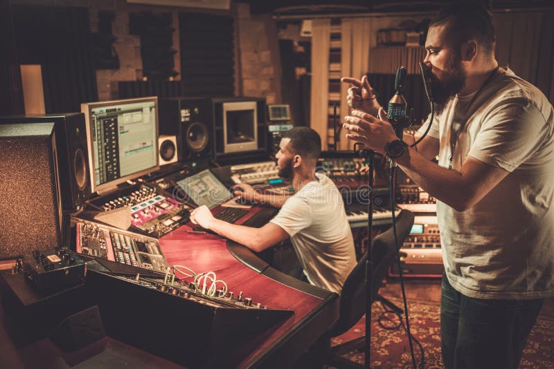 Sound engineer and singer recording song in boutique recording studio stock images
