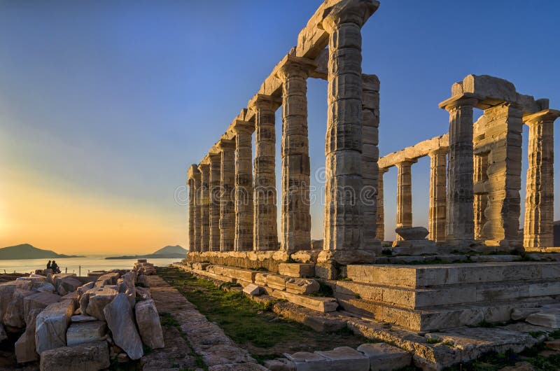Sounion, Attica / Greece: Colorful sunset at Cape Sounion and the ruins of the temple Poseidon with Patroklos island visible