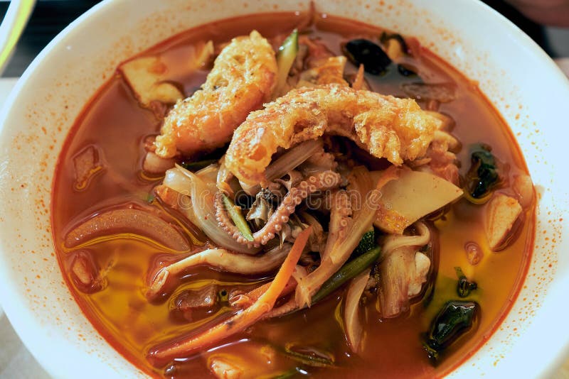 Soupe chinoise épicée chaude avec des nouilles et des fruits de mer servis avec le calmar frit à un restaurant célèbre dans image libre de droits Soupe chinoise épicée chaude avec des nouilles et des fruits de mer servis avec le calmar frit à un restaurant célèbre dans image libre de droits