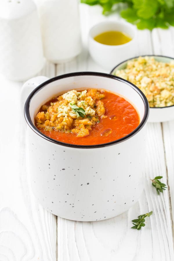 Soupe crème à tomate dans la tasse blanche, soupe d'un rouge ardent dans la tasse avec la chapelure parfumée, huile d'olive D?jeu photos libres de droits Soupe crème à tomate dans la tasse blanche, soupe d'un rouge ardent dans la tasse avec la chapelure parfumée, huile d'olive D?jeu photos libres de droits