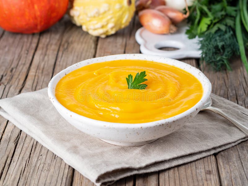 Soupe délicieuse à crème de potiron avec le persil sur le vieux rusti gris-foncé images libres de droits Soupe délicieuse à crème de potiron avec le persil sur le vieux rusti gris-foncé images libres de droits