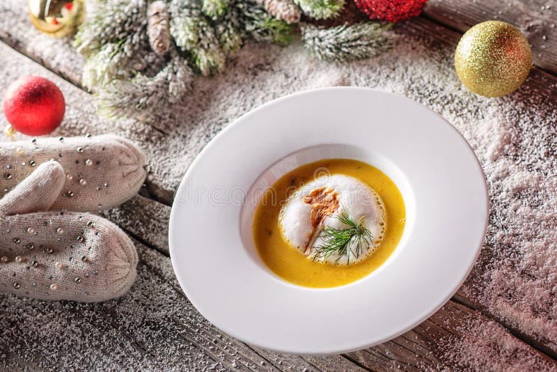 Soupe à poissons de Chrismas dans le plat blanc avec des décorations de Noël, gastronomie moderne image libre de droits Soupe à poissons de Chrismas dans le plat blanc avec des décorations de Noël, gastronomie moderne image libre de droits