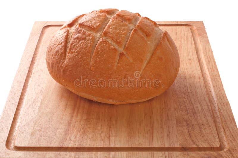 A loaf of sourdough bread on a wooden cutting board isolated against white, with clipping path. A loaf of sourdough bread on a wooden cutting board isolated against white, with clipping path.