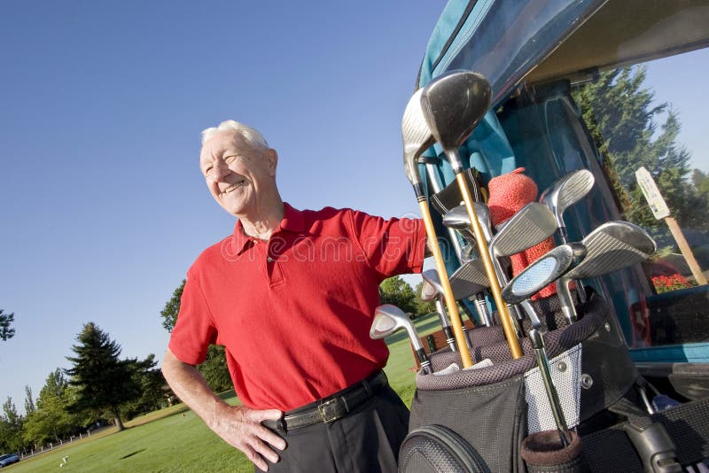 sourire d'homme de golf de chariot prochain à photos libres de droits sourire d'homme de golf de chariot prochain à photos libres de droits