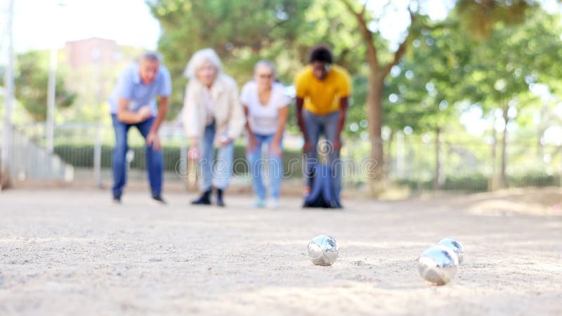 Sourire des gens matures jouant de la pétanque sur le sable ensemble clips vidéos