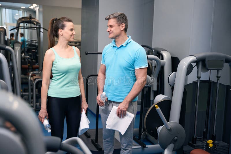 Sourire sportive dame parler à son partenaire de fitness avant de s'entraîner image libre de droits