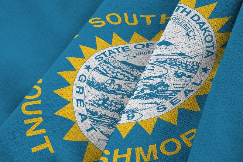 South Dakota US state flag with big folds waving close up under the studio light indoors. The official symbols and colors in fabric banner