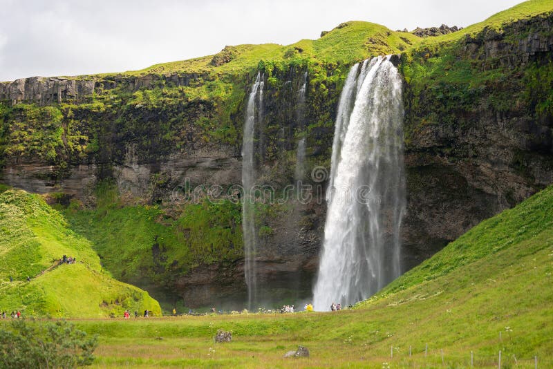 South Region, Iceland - July 29, 2019 - Tourists visiting the beautiful waterfall of Seljalandsfoss in the summer.
