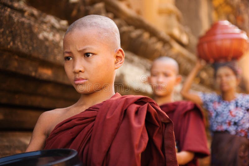 Southeast Asian young Buddhist monks walking morning alms