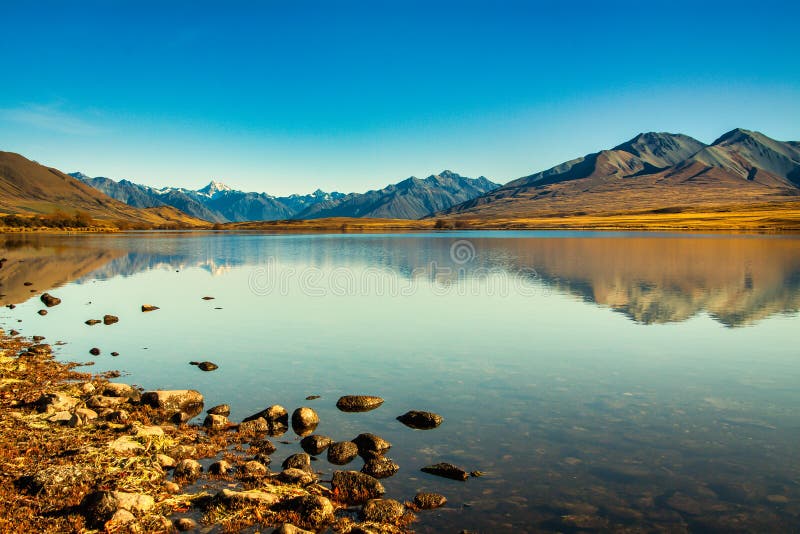 Southern Alps reflected in calm still water on Lake Clearwater, Ashburton Lakes high country