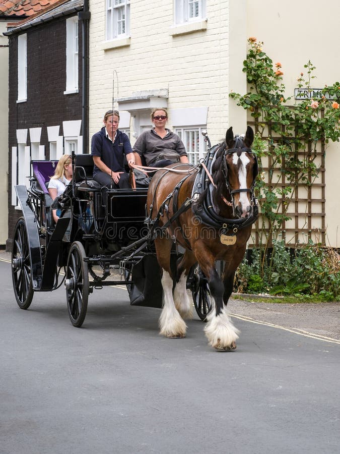 SOUTHWOLD, SUFFOLK/UK - 30 JUILLET : Les gens appréciant un cheval et un Ca photographie stock libre de droits SOUTHWOLD, SUFFOLK/UK - 30 JUILLET : Les gens appréciant un cheval et un Ca photographie stock libre de droits