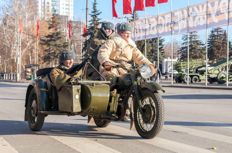 Soviet soldiers with weapons on the old army motorcycle