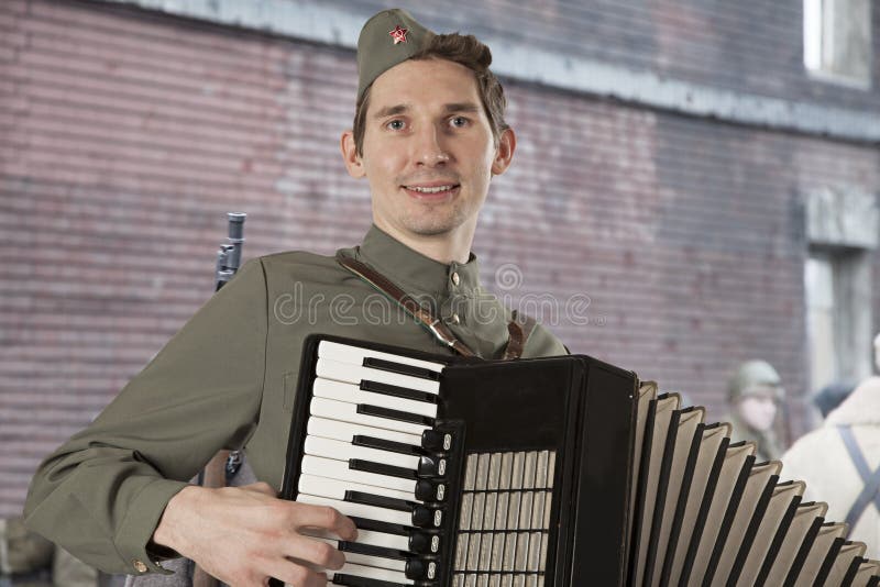 Sovjetisk soldat som utomhus spelar det dragspels- arkivbild Sovjetisk soldat som utomhus spelar det dragspels- arkivbild