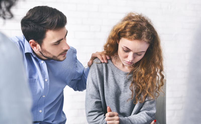 Soț grijuliu alinarea soției sale deprimate la întâlnirea cu consilierul de căsătorie stock images