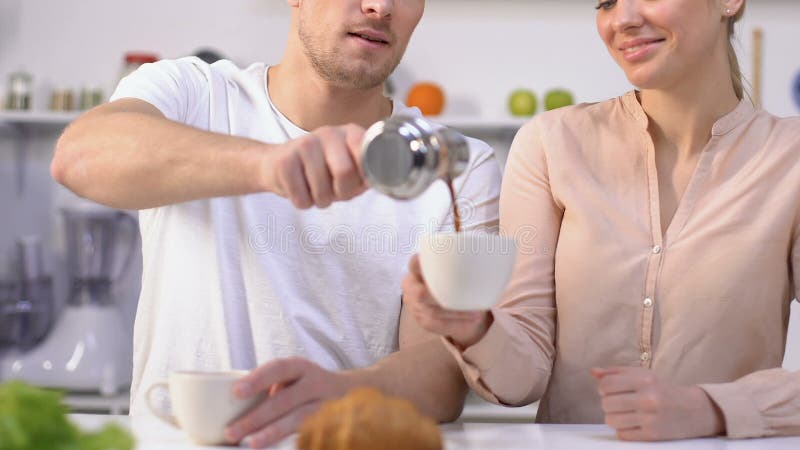 Soția își sărută soțul pe obraz și îți mulțumește pentru cafeaua de dimineață. stock footage
