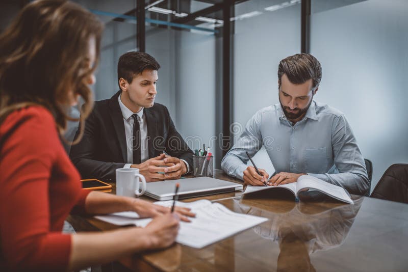 Soții care scriu o cerere de divorț cu avocatul lor stock image