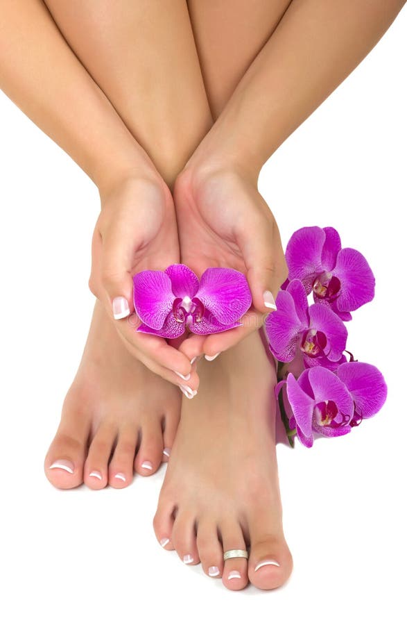 Pedicured piedi e curati mani con splendide orchidee.