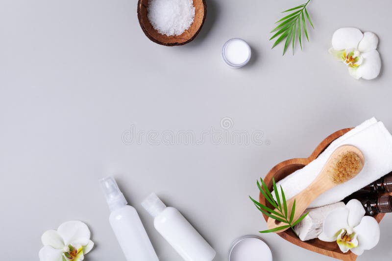 Spa, aromatherapy, beauty treatment and wellness background with massage brush, orchid flowers and cosmetic products. Top view and flat lay style