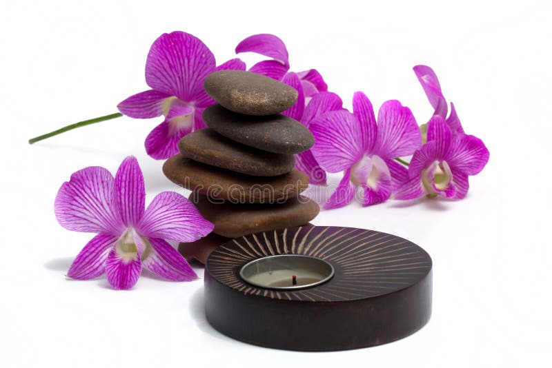 Spa candle and balanced stones with orchid