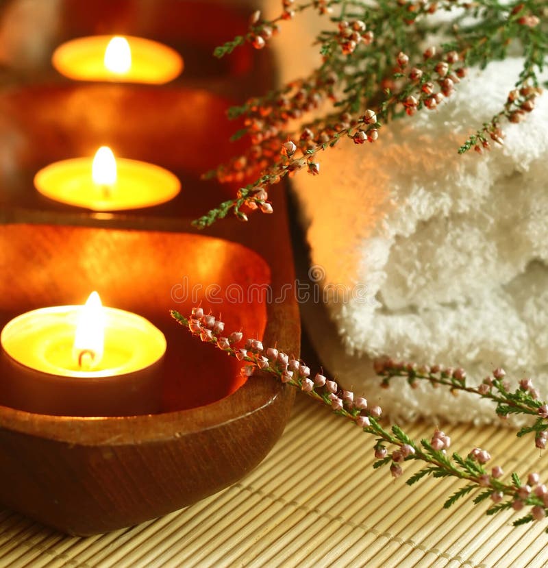 Spa composition of towel, candles and flowers.