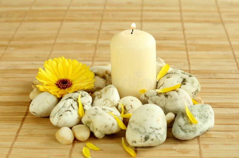 Spa concept. Candle, stones and flowers.