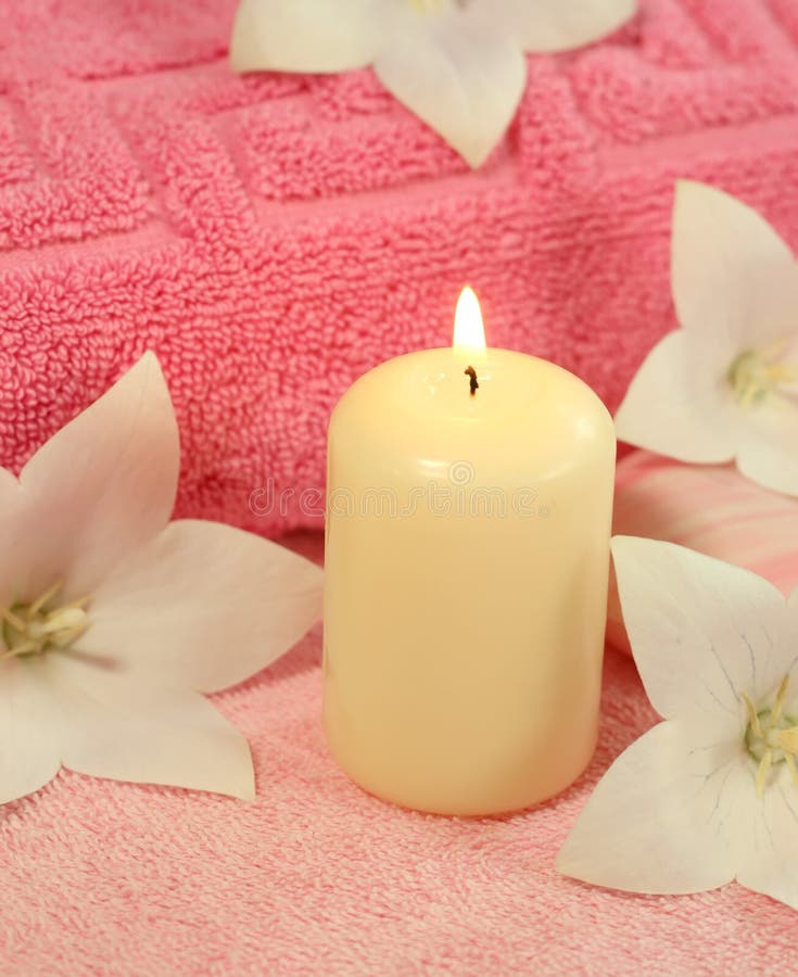 Spa concept. Candle, towel and flowers.