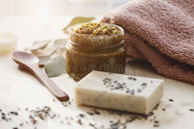 Spa cosmetic products, milk soap, handmade sugar coffee scrub with coconut oil in glass jar and towel