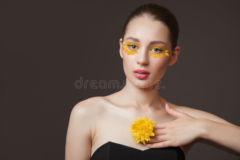 Spa portrait of a young woman. Flowers on her face. The concept of skin and body care. Perfect skin health stock photography Spa portrait of a young woman. Flowers on her face. The concept of skin and body care. Perfect skin health stock photography