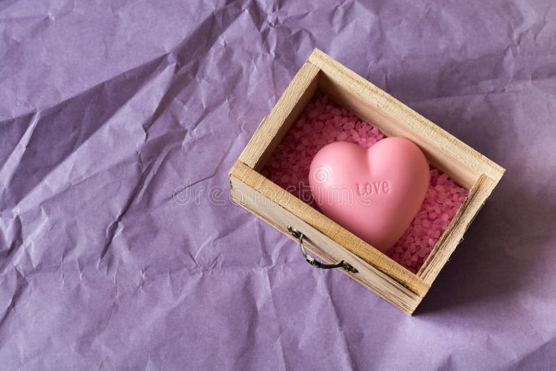 Spa and wellness concept: wooden box with pink sea salt and heart shape soap with word `love` on it royalty free stock images Spa and wellness concept: wooden box with pink sea salt and heart shape soap with word `love` on it royalty free stock images