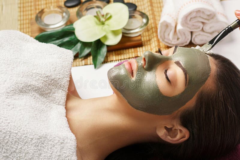 Spa Woman applying Facial clay Mask. Beauty Treatments. Close-up