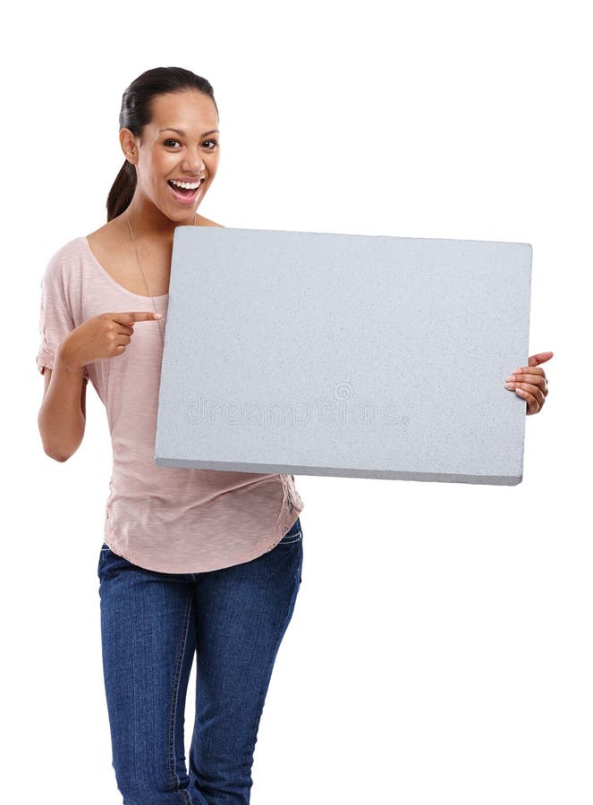 This space could be yours. Portrait of an attractive young woman in a studio pointing at a board shes holding isolated stock photos