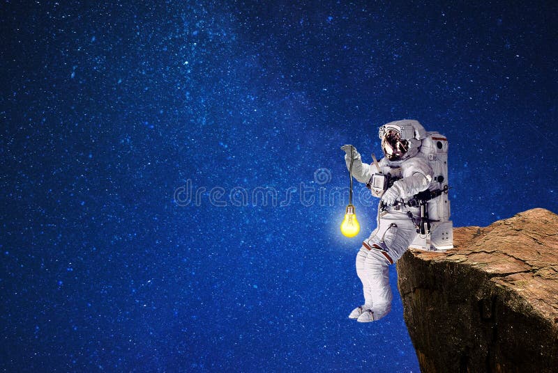 Spaceman lighting witch light bulb route in galaxy royalty free stock photography