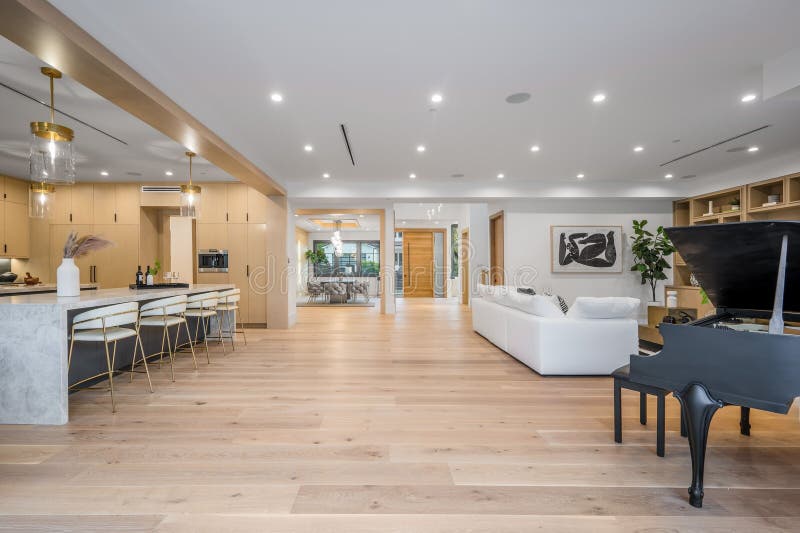 Spacious open-plan kitchen with a grand piano in the corner stock photography