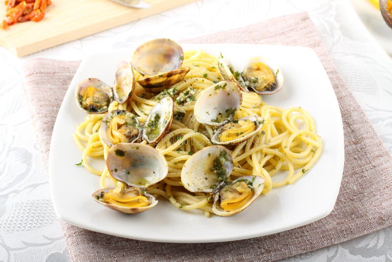 Spaghetti with fresh clams, garlic and parsley. On complex background stock photography