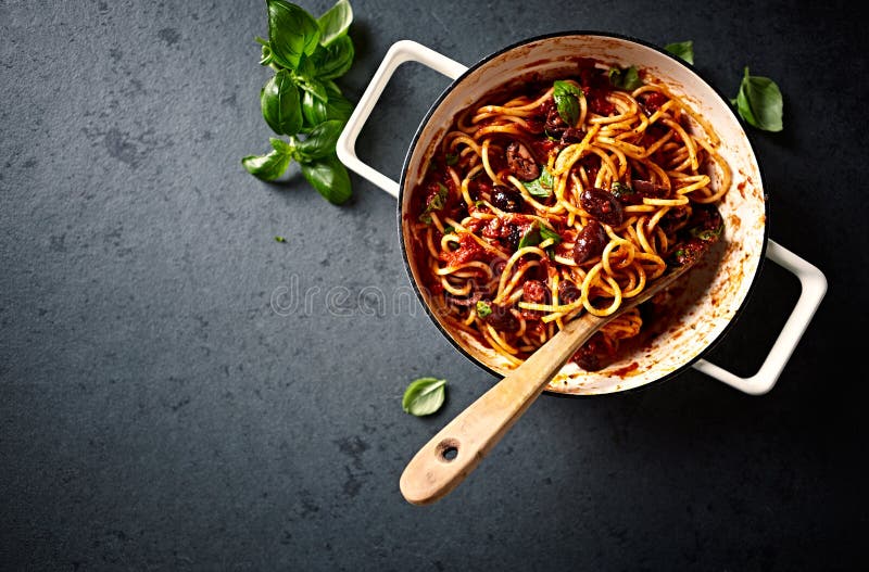 Spaghetti with fresh Tomato Sauce, Kalamata Olives and Basil in a Cooking Pan seen from above