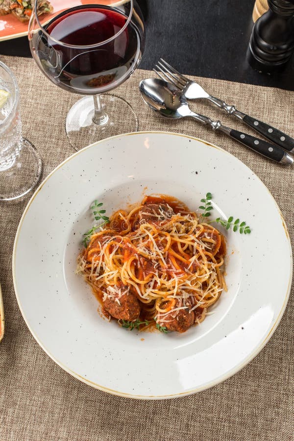 Spaghetti with Meatballs and Tomato Sauce and Glass of Red Wine on the