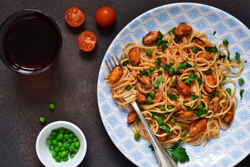 Spaghetti with Mussels and Green Peas in Tomato Sauce Stock Photo
