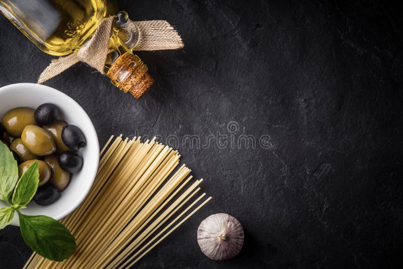 Spaghetti, olives and olive oil on the black stone table royalty free stock photo Spaghetti, olives and olive oil on the black stone table royalty free stock photo
