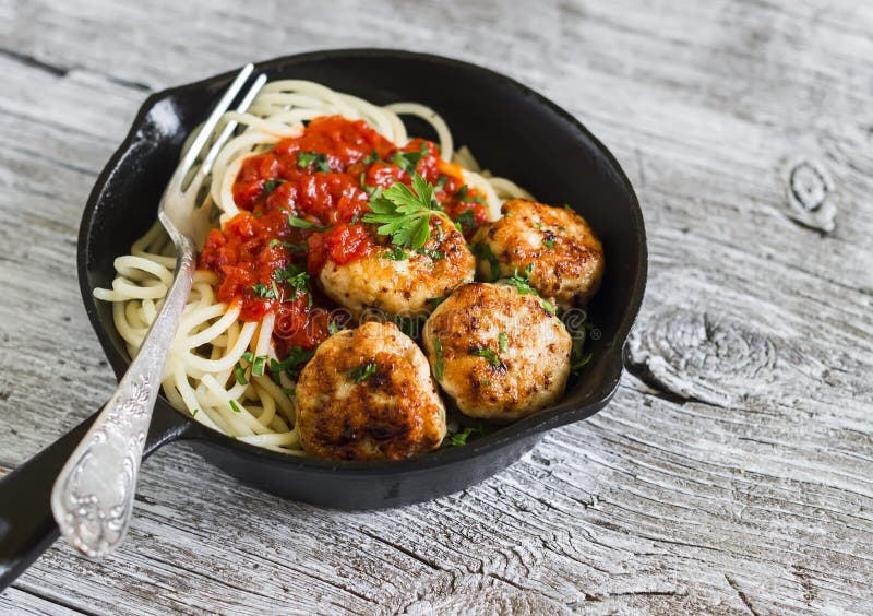 Spaghetti with tomato sauce and chicken meatballs in a pan