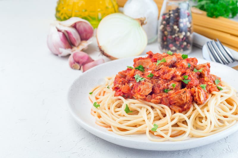 Spaghetti with tuna and tomato basil sauce garnished with parsley, horizontal, copy space