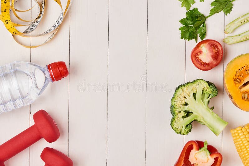 Spansk peppar med att mäta bandet, hantlar och flaskan av vatten, arkivbild Spansk peppar med att mäta bandet, hantlar och flaskan av vatten, arkivbild