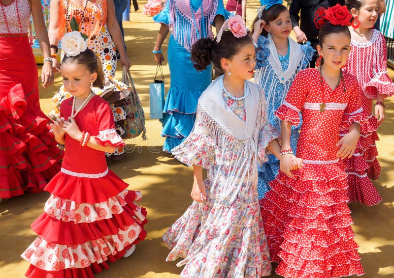 Spanska flickor i traditionell klänning som tillsammans med går Casitas på den Seville mässan