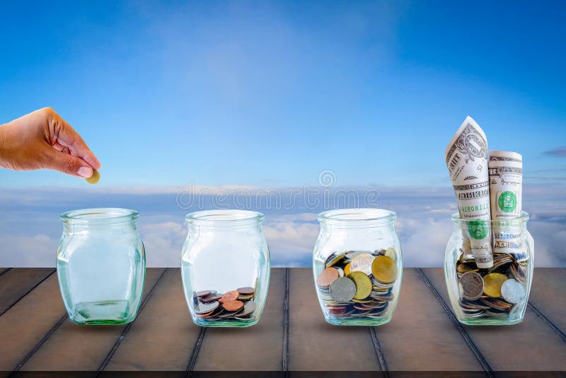 Saving  money. A hand putting money in bottle on sky and old wood background. The coins in the bottle for save money. Photo financial saving and  Saving  money. Saving  money. A hand putting money in bottle on sky and old wood background. The coins in the bottle for save money. Photo financial saving and  Saving  money