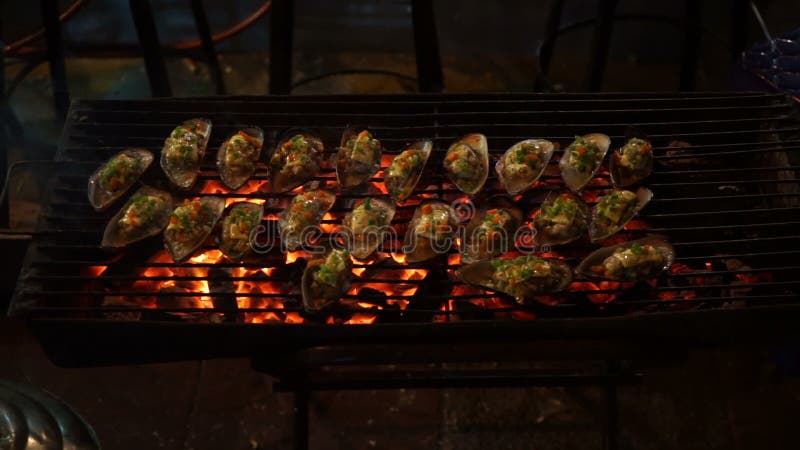 Sparato di un processo di cottura dei frutti di mare su un barbecue su un mercato asiatico di notte video d archivio