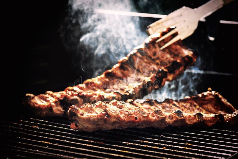 Spare ribs cooking on barbecue grill for summer outdoor party. F